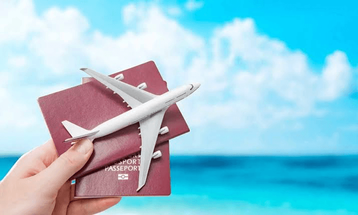 Passports and a model airplane against a coastal backdrop